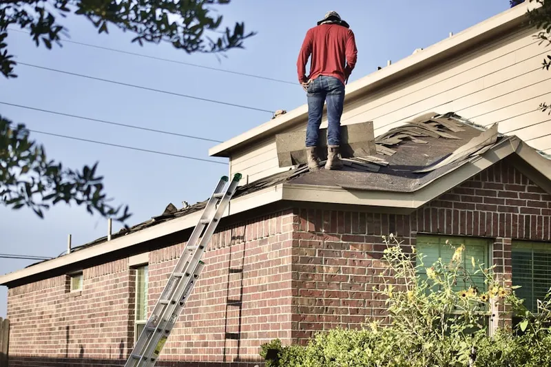 Professional roofer working on a residential roof in Glenwood Village
